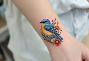 Puffy bluebird surrounded by wild flowers tattoo idea