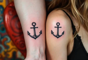 Matching man and woman tiny black anchor tattoos, the father’s on the upper arm tattoo idea