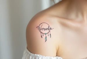 Verunka name encircled by a light teal dreamcatcher, with tiny feathers. tattoo idea