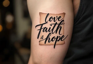 Tattoo with black calligraphy love faith hope on a parchment-scroll background in faded tan and beige tones. tattoo idea