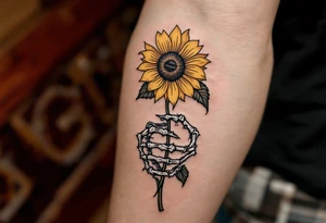 A skeleton hand holding a dying yellow sunflower, "memento mori" in thin, winding black cursive along the stem. tattoo idea