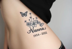 flowers and butterflies with the name “NANA” and the date “1954-2022” mixed all together on the side of the rib cage tattoo idea