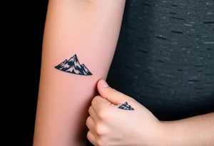 A pair of minimalist black and blue mountain peaks, one tattooed on the father’s forearm and the matching smaller version on the child’s wrist. tattoo idea