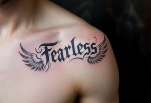 “Fearless” in steel gray Gothic style, flanked by wing motifs in faded charcoal. tattoo idea