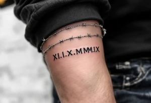 XI.XI.MMIX inked in matte black on the hand’s edge, accompanied by silver barbed wire surrounding it. tattoo idea