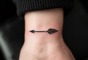 A sleek black ink arrow with a delicate gold accent running along its shaft, symbolizing elegance and direction. tattoo idea