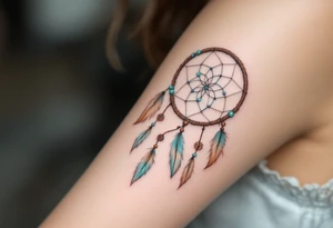 Dreamcatcher (česky lapač snů) tattoo featuring soft turquoise and beige feathers, a brown woven hoop with light blue beads, symbolizing protection and peaceful dreams in a delicate, boho style. tattoo idea