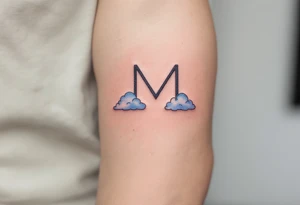 A soft "M" in sky blue with subtle cloud-like shading. tattoo idea