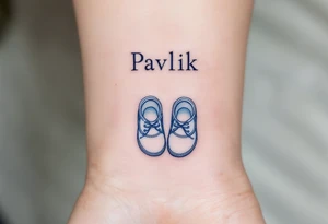 Pavlík written above a tiny pair of baby shoes in dusty blue. tattoo idea