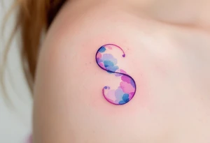 A soft watercolor "S" blending shades of pink, blue, and purple with a dreamy effect. tattoo idea