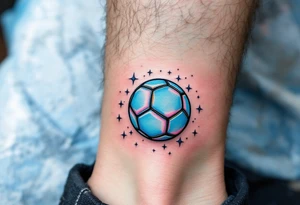 A small ankle tattoo of a pastel blue soccer ball with sparkles around it for a playful look. tattoo idea