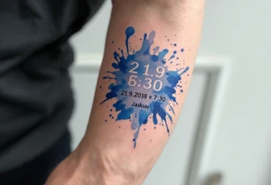 Bold numbers "21.9.2018 v 7:30" with the name "Jakub" beneath, surrounded by a blue watercolor splash. tattoo idea
