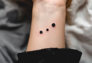 Three charcoal black dots tattoo idea
