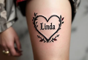 A vintage heart with bold black outlines, with name "Linda" in a traditional font, surrounded by small red roses and green leaves for a timeless look. tattoo idea