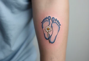 Light blue and soft gray footprints of Jakub, encircled by a small, blooming daisy to signify his pure and gentle spirit. tattoo idea