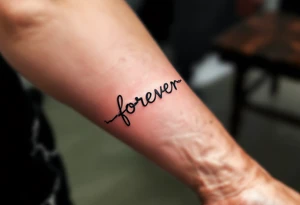 A delicate chain spelling "forever" in soft gray, with a tiny broken link near the end. tattoo idea