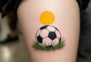 A detailed soccer ball resting on green grass with a bright yellow sun overhead. tattoo idea