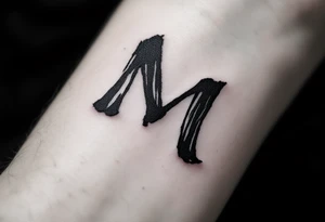 A handwritten "M" in ink-wash black, giving it a natural, imperfect flow. tattoo idea
