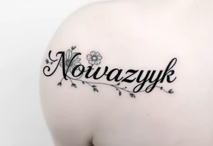 The word "Nowaczyk" with three flowers and vines on the lower tricep, medium size tattoo idea