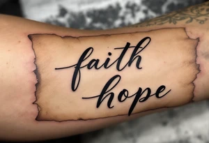 Tattoo with black calligraphy love faith hope on a parchment-scroll background in faded tan and beige tones. tattoo idea