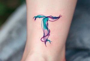 A watercolor-style "T" in shades of turquoise and purple, blending like paint strokes. tattoo idea