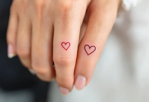 Tiny matching red heart outlines tattooed on the inside of each partner’s ring finger, symbolizing a hidden but everlasting bond. tattoo idea