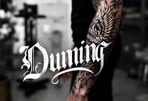 Dunning, left forearm details include angel wing, greek type of font,jungle leaves, name is big and in white color tattoo idea