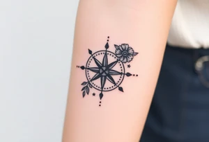 Compass with cursive letters with flowers flowing above and below tattoo idea