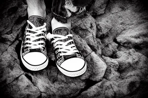 Guy alone on a cliff with shoes in hand tattoo idea