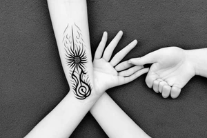 A hand holding fire with a banner tattoo idea