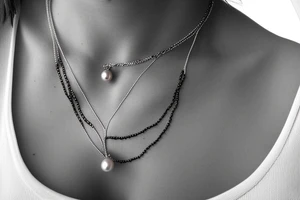 necklace made of sea snake with black pearl pendant tattoo idea