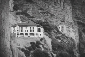 outline of a villa on the cliffs with a pass to it looking at it from the bottom of the pass. thigh-sized. tattoo idea