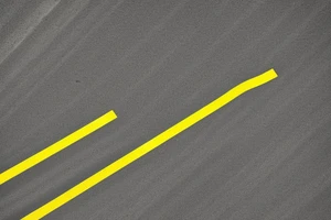 Black asphalt road with yellow parallel stripes shot from above tattoo idea