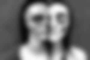 A male face that should represent both birth and death. The left side of the face should represent birth and the right side should represent death. The face should be Partly covered by a hood tattoo idea
