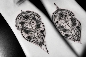 Red gemstone with black and grey filigree surrounding it tattoo idea