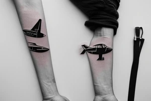 a minimal tattoo shows an airplane flying out of a suitcase to travel tattoo idea
