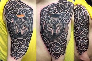 Left shoulder with Celtic cross plus wolf with yellow eyes tattoo idea