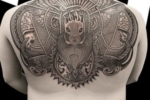 Upper back tattoo. The tattoo is a tribal mesh that includes the following items: fishing Hook, Fox, colon, Lion, Honey bee, Lock and key, Top hat, King’s Crown, crescent moon, anchor, wings. tattoo idea
